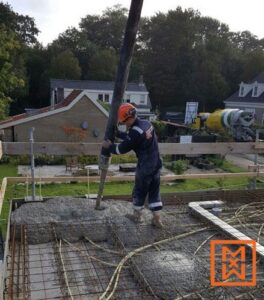 Bouwvakker die beton stort op een bouwplaats