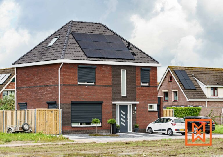 Moderne bakstenen woning met twee verdiepingen, zonnepanelen op het dak en donkergrijze rolluiken voor de ramen. Nummer 25 is zichtbaar op de voordeur. Een witte auto staat geparkeerd op de oprit. Het huis staat aan een nieuw ontwikkelde straat met andere, vergelijkbare huizen.
