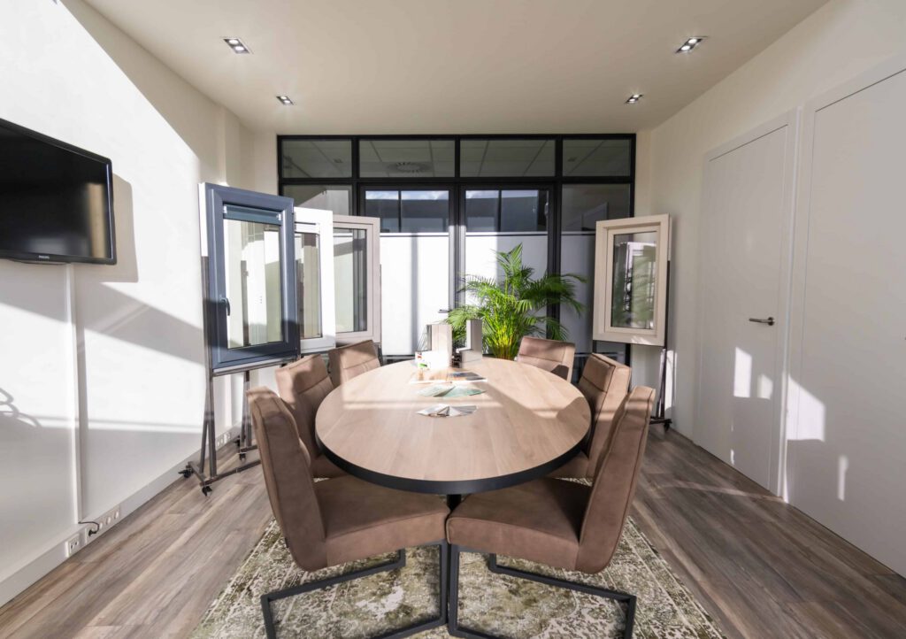 Moderne kantoorvergaderruimte met etalages en een lichte houten tafel. Door Van Weenen Bouwbedrijf