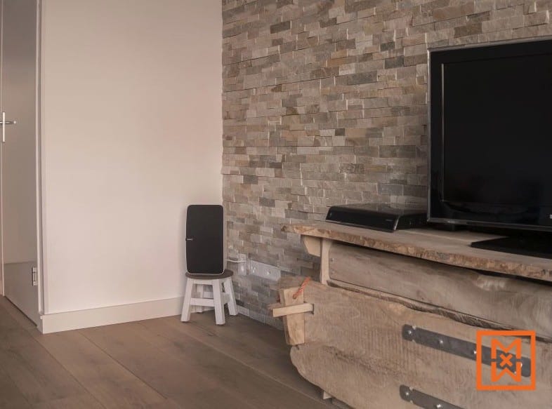 Rustieke houten mediaconsole met tv, luidspreker en stenen muur. Interieurontwerp. door Van Weenen Bouwbedrijf