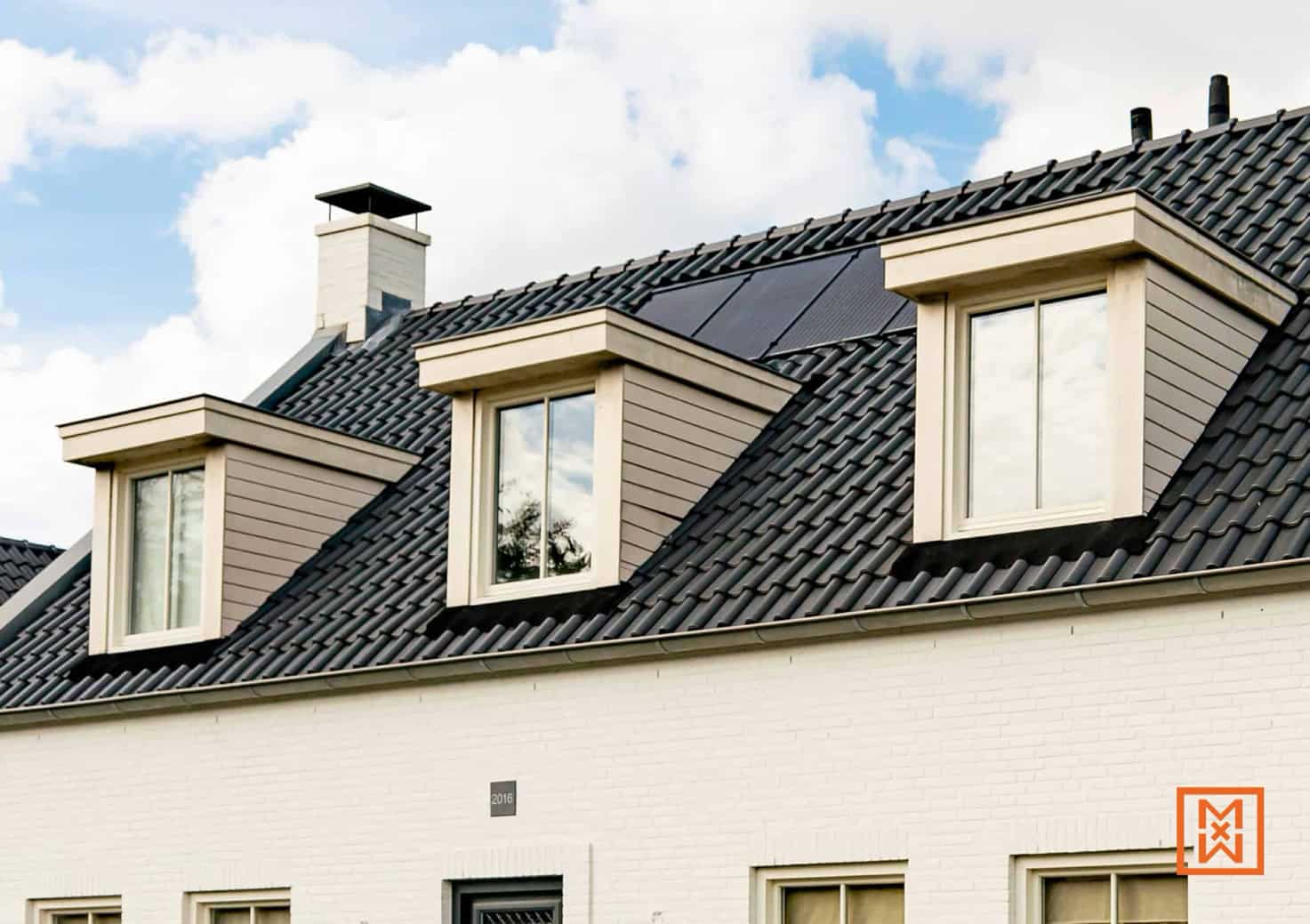 Drie dakkapellen met witte kozijnen op een dak met zwarte dakpannen. Zonnepanelen zijn discreet geïntegreerd. De gevel is wit geschilderd. Modern en energiezuinig design.