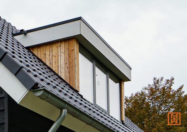 Dakvenster met houten bekleding en grijze dakpannen. Moderne architectuur met strakke lijnen en natuurlijke materialen.