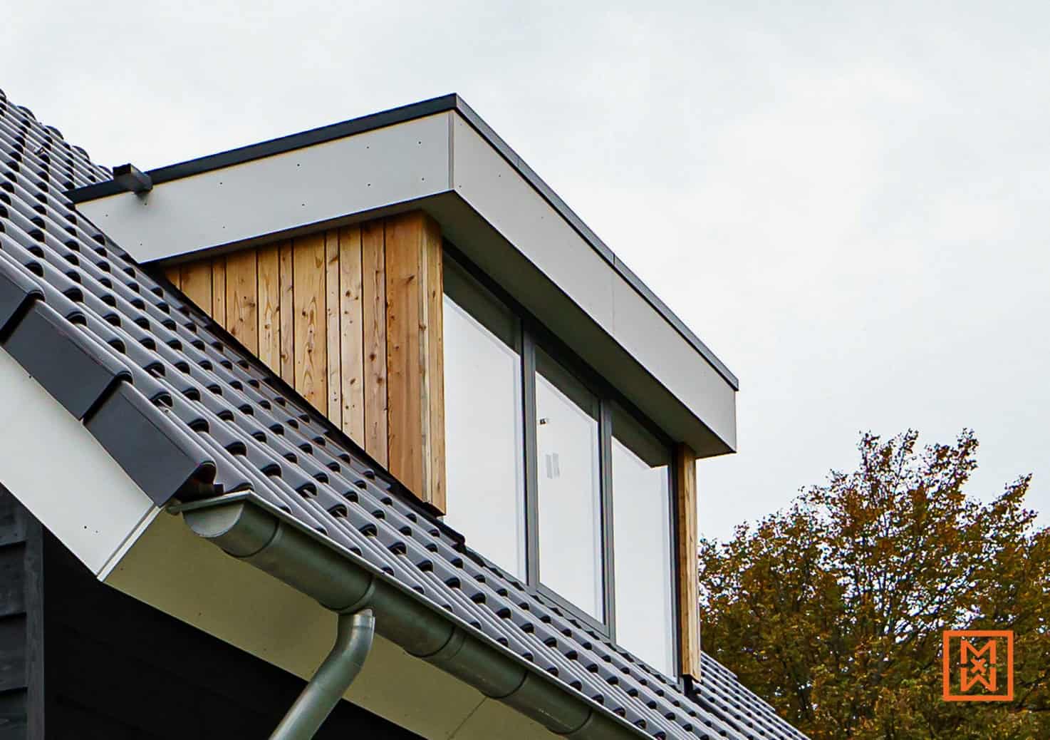 Dakvenster met houten bekleding en grijze dakpannen. Moderne architectuur met strakke lijnen en natuurlijke materialen.