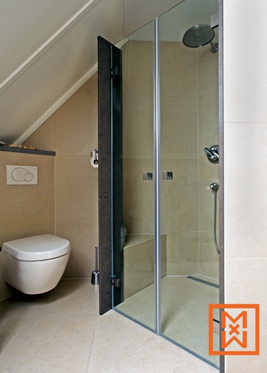 Moderne, kleine badkamer met beige tegels, een hangend toilet en een frameloze glazen douchecabine met een ingebouwde zitbank. De douche heeft een donkergrijs frame en een regendouchekop.